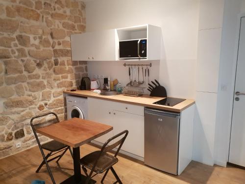 巴黎透明玛莱公寓的小厨房配有桌子和桌椅