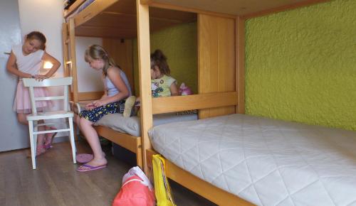 波尔特拜VVF Cotentin Îles anglo-normandes的三个女孩坐在房间里双层床上
