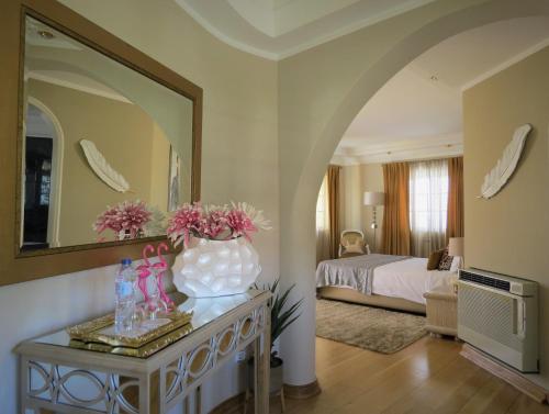 波尔蒂芒Villa Moments - Guest House的一间卧室,配有一张床,桌子上放着花瓶