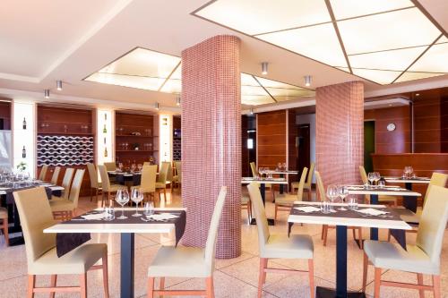 焦维纳佐巴里焦维纳佐宜必思尚品酒店的用餐室配有桌椅和桌椅