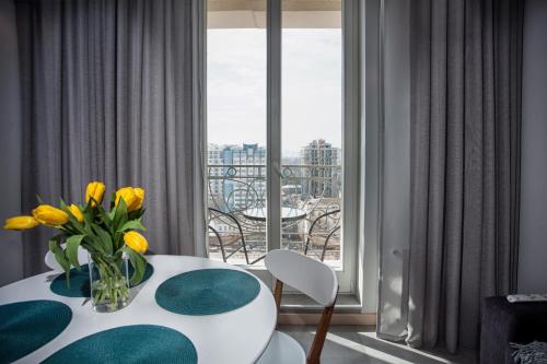 敖德萨Apartments Belietazh的一间设有一张桌子的房间,花瓶是黄色的