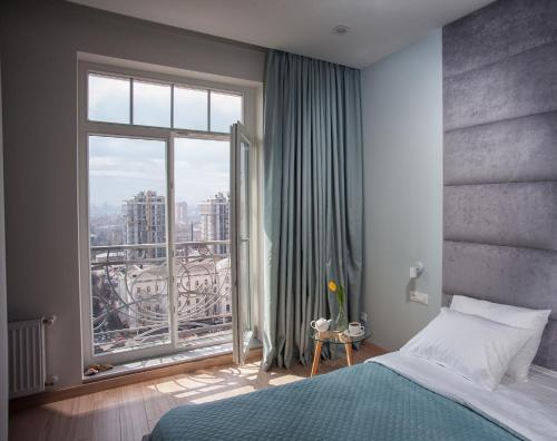 敖德萨Apartments Belietazh的一间卧室设有一张床和一个大窗户