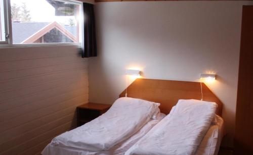 Årøy依文特利吉斯咖雷特酒店的一间卧室配有一张带白色床单的床和一扇窗户。