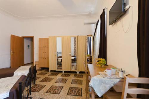 罗马Hostel Castello Maggiore的带两张床和一张桌子的房间以及一间用餐室