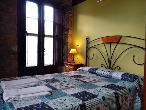 坎加斯-德奥尼斯Hotel Rural Posada Del Monasterio的一间卧室配有床,床上装有被子