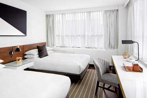 华盛顿The St Gregory Hotel Dupont Circle Georgetown的酒店客房配有两张床和一张书桌