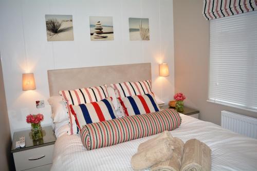 本莱赫Ein Yfory的卧室配有一张带两个条纹枕头的白色床