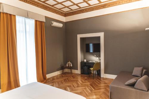 那不勒斯雷丽斯黛拉佩特旅馆的一间卧室配有一张床、一张沙发和一张书桌