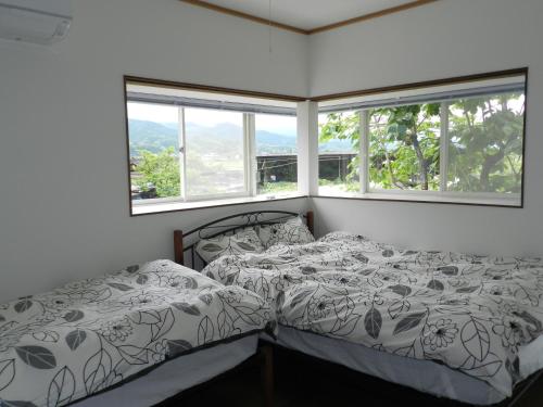 TaragiB&B Toyonoakari的一间卧室设有两张床和两个窗户。