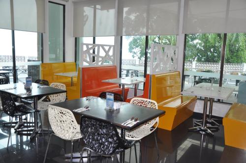 波德申迪克森港口克拉娜海滩度假村的餐厅设有桌椅和窗户。