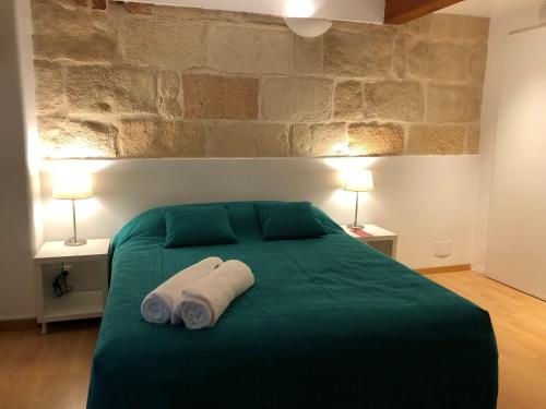休达德亚Hostel Menorca的一间卧室配有绿床和2条毛巾