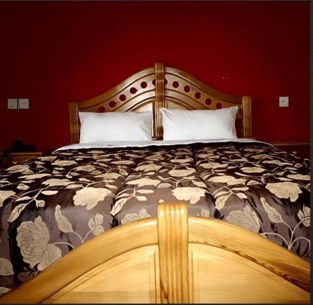 伊穆泽尔杜坎达波特阿特拉斯酒店的一间卧室配有一张大床和木制床头板
