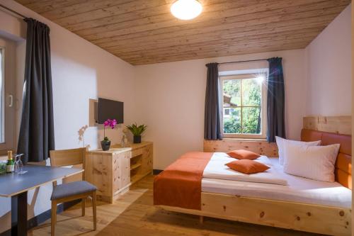 锡利安Refugium Dolomiten & Chalet的一间卧室配有一张床、一张书桌和一个窗户。