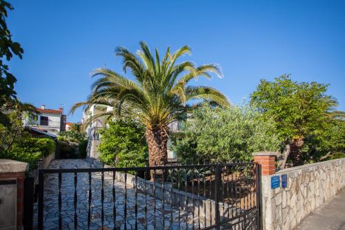 茨雷斯Villa Vosilla Apartments的房屋前有棕榈树的围栏