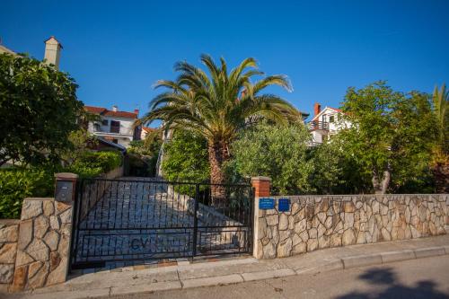 茨雷斯Villa Vosilla Apartments的一座拥有石墙和棕榈树的大门