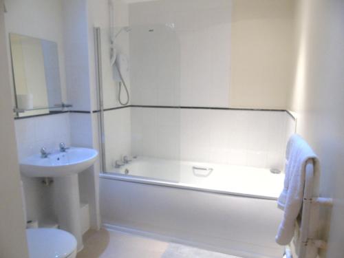 利物浦利物浦两卧室公寓 的白色的浴室设有浴缸和水槽。