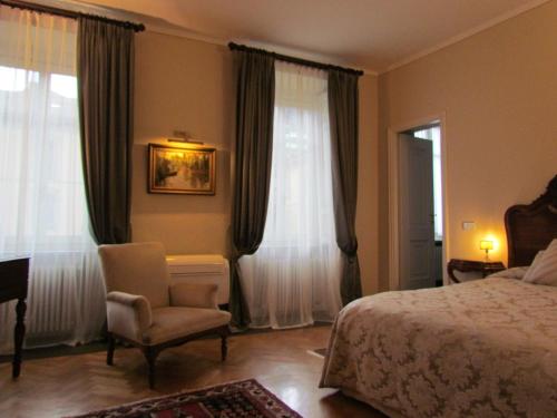 科莫亚婆罗多圣安格斯蒂诺住宿加早餐旅馆的一间卧室配有一张床、一把椅子和窗户。