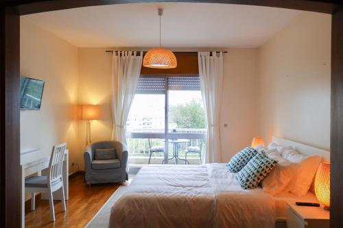 加亚新城Origami Porto Residência & Hostel的一间卧室配有一张床、一张书桌和一个窗户。