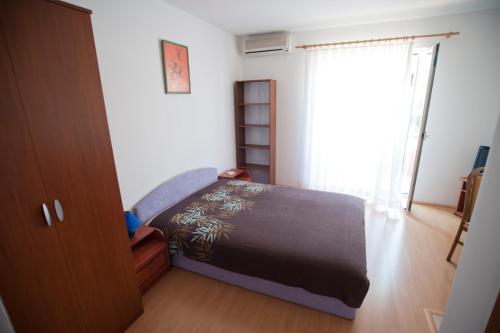 乌马格Apartments Maric with parking的一间卧室设有一张床和一个窗口