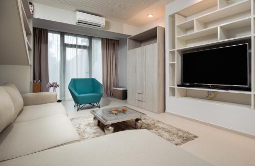 斯普利特博班豪华套房酒店的客厅配有电视、沙发和椅子
