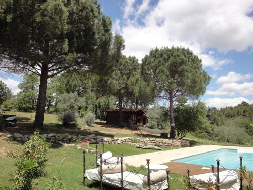 Saint-Christol-lès-Alès马斯米科库里尔斯酒店的一个带椅子的游泳池和一个背景房子