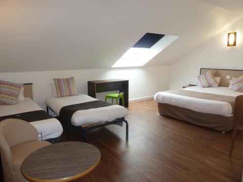 勒芒Campanile Le Mans Est的客房设有三张床和天窗。