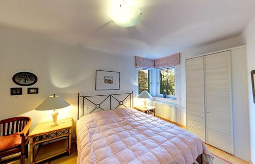 黑灵斯多夫Villa Seepark - Ferienwohnung 5的一间卧室配有一张床、两盏灯和一个窗户。