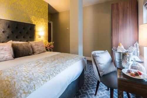 伦敦德里施奎精品酒店的酒店客房配有一张床、一张桌子和一把椅子。