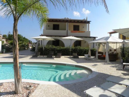利帕里博尔戈伊欧利酒店的一座棕榈树和房子的游泳池
