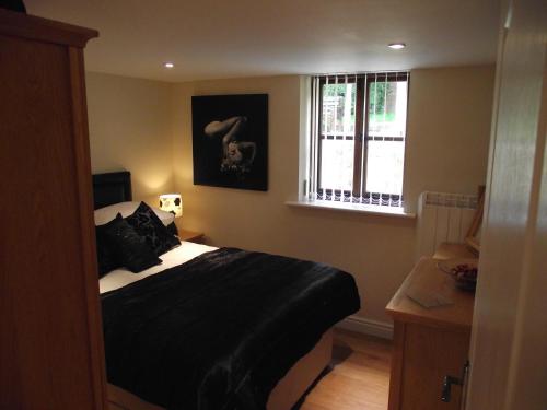 Llanishen木匠别墅酒店的一间卧室设有一张黑色的床和一个窗户。