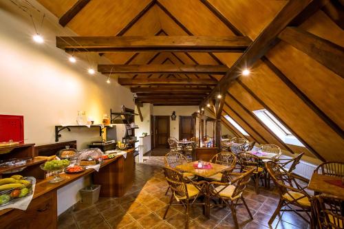 捷克克鲁姆洛夫阿卡迪公寓酒店的一间厨房和带木制天花板及桌子的用餐室