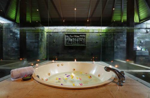 Prigen芬娜高尔夫乡村俱乐部的浴室配有浴缸,浴室内备有蜡烛