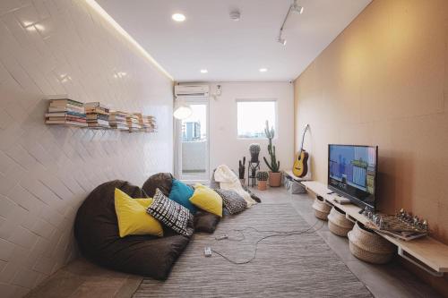 雅加达雅加达孔科旅舍的带沙发和平面电视的客厅