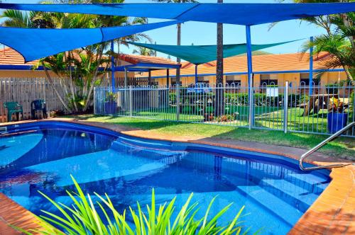 扬巴扬巴双松汽车旅馆的一座房子旁带蓝伞的游泳池