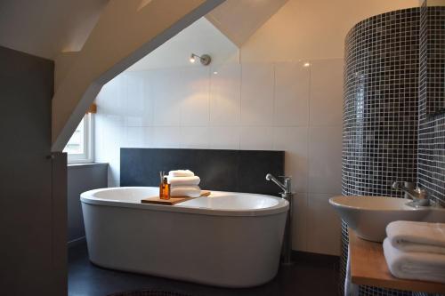 奥斯特豪特Zzzuite25的一间带大浴缸和水槽的浴室