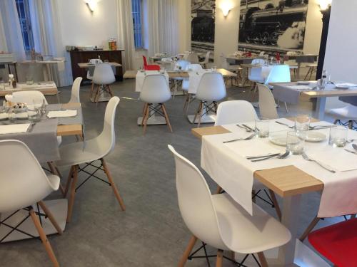 勒威诺Hotel Internazionale Luino的用餐室配有白色的桌子和白色的椅子