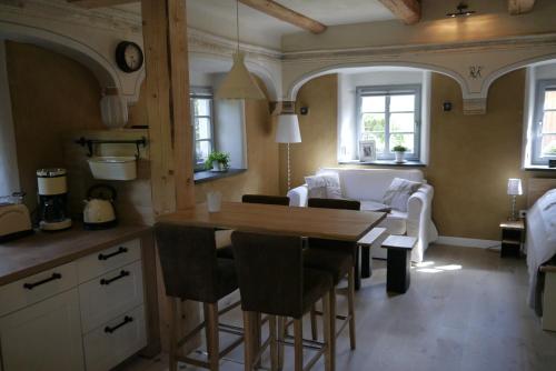 梅森Ferienwohnung "Alte Bauernstube"的厨房以及带桌椅的起居室。
