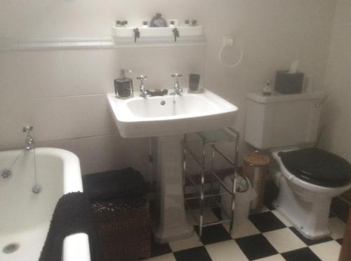 珀肖尔Arden Croft的浴室配有盥洗盆、卫生间和浴缸。