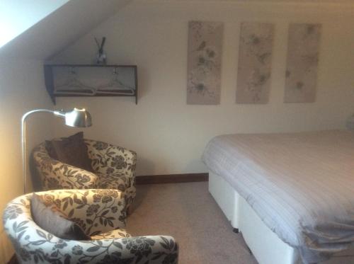 珀肖尔Arden Croft的一间卧室配有一张床、一把椅子和一盏灯