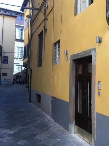 卢卡Il Pozzo di Santa Zita的街上有门的黄色建筑