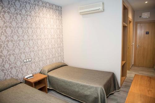 西曼卡斯西曼卡斯酒店的小房间设有床和沙发