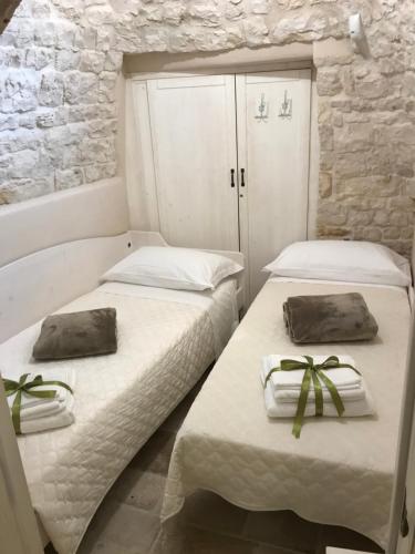 阿尔贝罗贝洛Suite Curcuma的客房内的两张床和毛巾