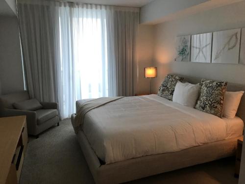 哈兰代尔海滩Beach Walk Resort De Lux Apartment的卧室配有床、椅子和窗户。