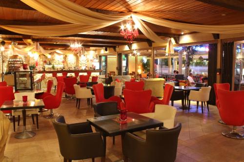 法里拉基迪米特拉酒店的一间设有红色桌椅的餐厅和一间酒吧