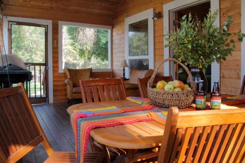Willow CreekCoho Cottages的门廊上的木桌和椅子,设有用餐室