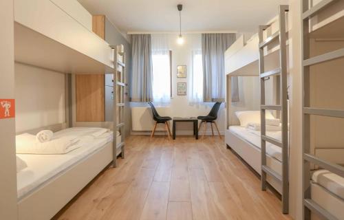 萨拉热窝Hostel Kucha的客房设有两张双层床和一张桌子。