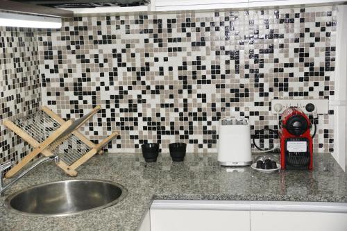 布宜诺斯艾利斯Lola's Home的带水槽的厨房台面和瓷砖墙