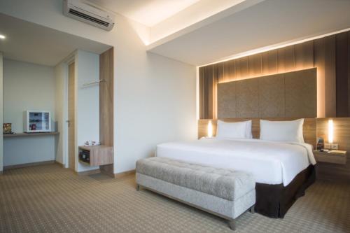 雅加达Grand G7 Hotel Kemayoran的卧室配有一张白色大床和一把椅子