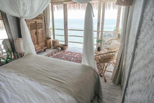 乌鲁瓦图德雷姆西巴厘度假村的一间卧室配有一张床,享有海景