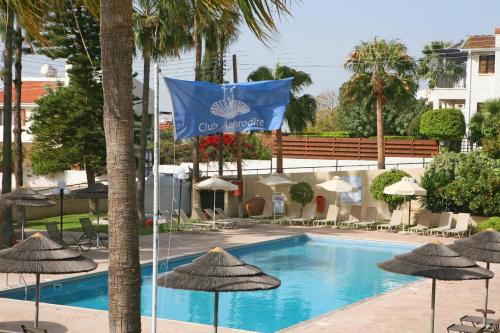 厄瑞米阿芙罗狄蒂倶乐部酒店的游泳池旁的旗帜,带遮阳伞